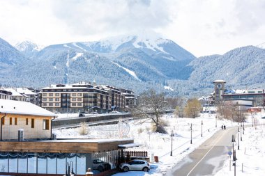 Bansko, Bulgaristan - 7 Nisan 2025: Glazne nehri, Bulgar kenti, otel evleri ve kar Todorka zirvesi Pirin dağlarında