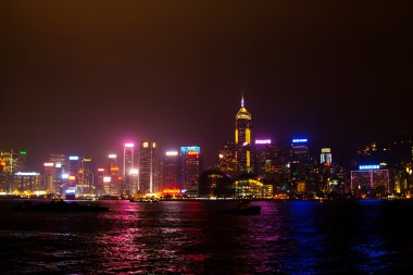 Gece Hong Kong. Nehir ve ışıklandırılmış gökdelenler görünümü