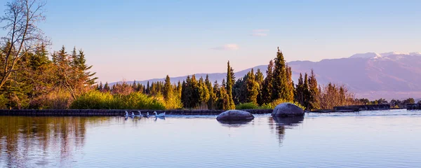 Schöner Panoramahintergrund mit See, Stein, Gänsen, Bergen am blauen Himmel — Stockfoto