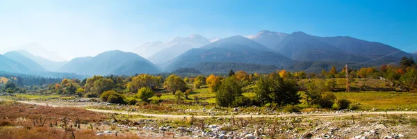 Vibrant autumn panorama background with colorful green, red,  yellow trees and mountains peaks — Stock Photo, Image