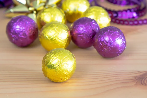 Décoration de vacances, boules de bonbons dorées pourpres et jaunes gros plan — Photo