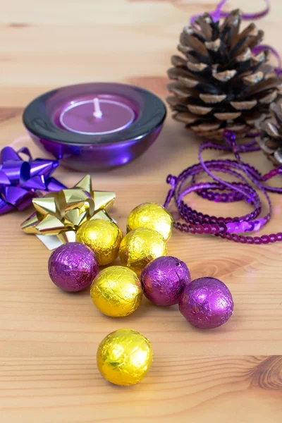 クリスマスの休日の装飾、紫と黄色の黄金甘いキャンディー ボール、キャンドル、松かさ — ストック写真