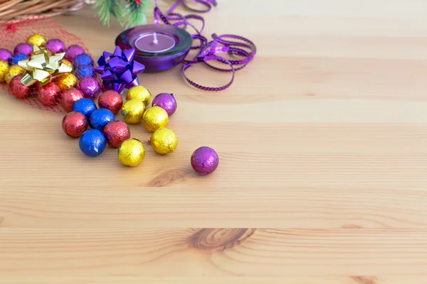 Decorazione natalizia, palline di caramelle dorate viola e gialle, candela, copyspace — Foto Stock
