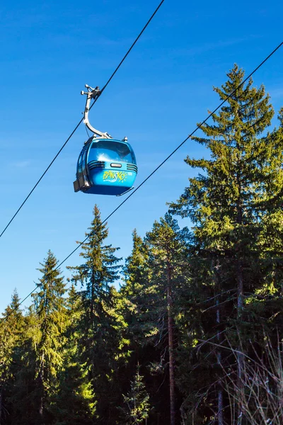Close up Bansko cable car cabin, pine trees  against vibrant blue sky, Bulgaria — Stock Photo, Image