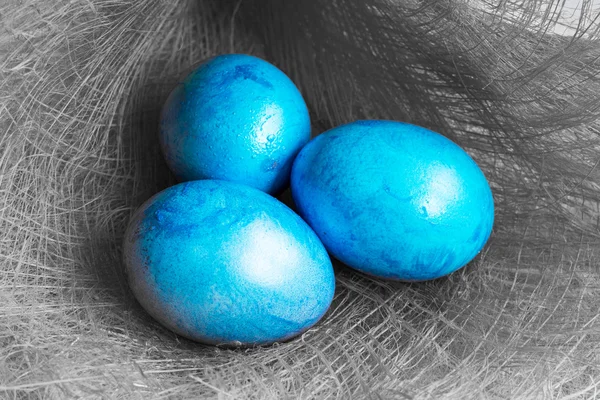 Tre uova di Pasqua blu su sfondo grigio — Foto Stock