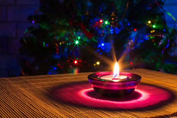 Natale sfondo vacanza con candela viola e luci colorate con copyspace — Foto Stock