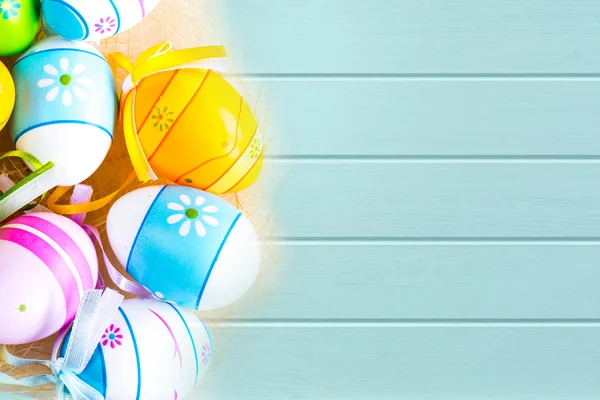 Vibrant holiday colorful Easter eggs on turquoise wooden planks background — Stock Photo, Image