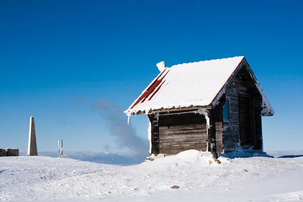 Vacation rural winter background. Small wooden alpine house covered with snow — Stock Photo, Image