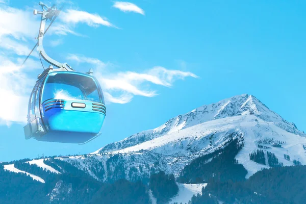 Vibrant travel ski background with cable car cabin, slopes, snow mountain peak, copyspace