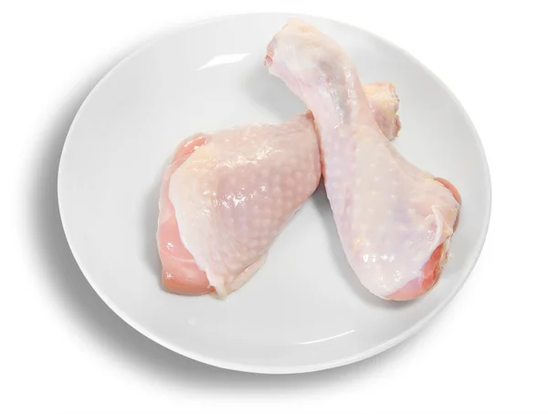 Dvě nohy syrové kuře na bílém štítku — Stock fotografie