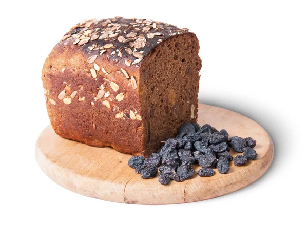 Unleavened bread with seeds on wooden board with raisins — Stock Photo, Image