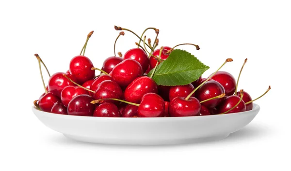 Pile of sweet cherries with leaf on white plate — Stock Photo, Image