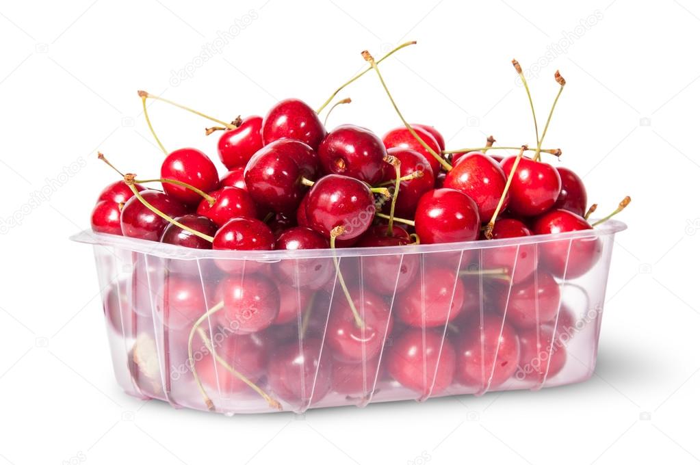 Red juicy sweet cherries in a plastic tray rotated