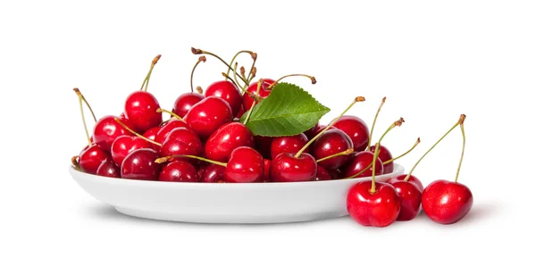 Sweet cherries with leaf on white plate and three near — Stock Photo, Image