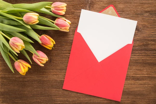 Flores e envelope em fundo de madeira — Fotografia de Stock