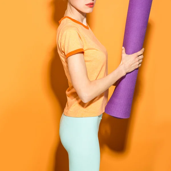 Ragazza di yoga con un tappetino yoga sopra — Foto Stock