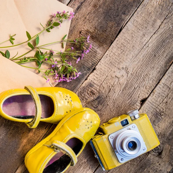 Fundo com coisas retro como câmera, sapatos de bebê, envoltório com flores — Fotografia de Stock