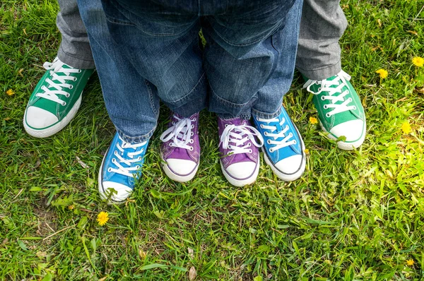 Familie Beine auf grünem Gras — Stockfoto