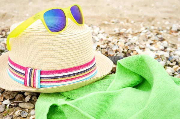 Chapéu de palha, óculos de sol e em uma praia — Fotografia de Stock