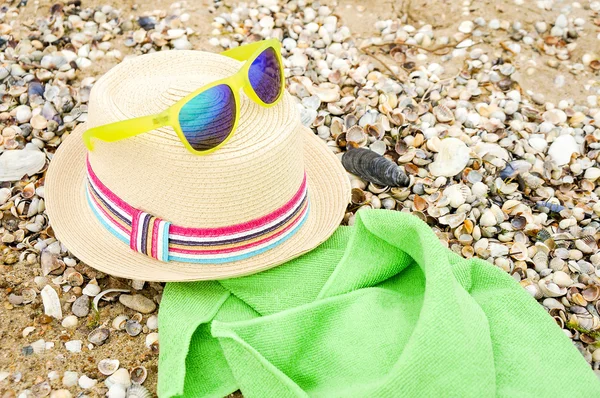 Chapéu de palha, óculos de sol e em uma praia — Fotografia de Stock