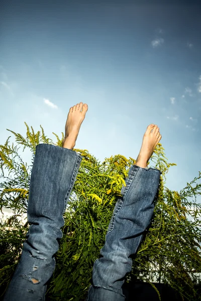 Pernas em jeans sobre o céu — Fotografia de Stock