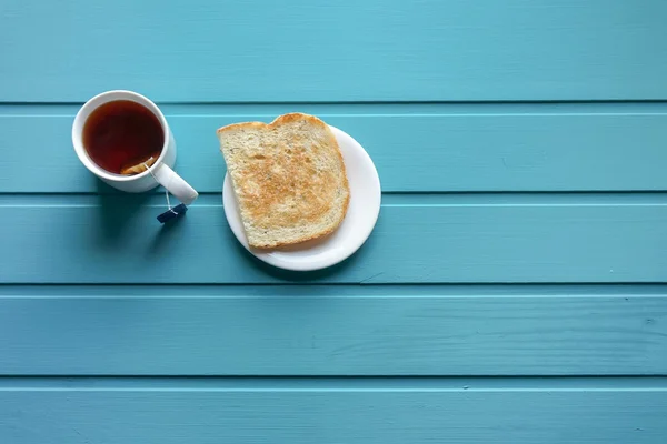 Manhã café da manhã com torradas e chá sobre fundo azul, foco em torradas — Fotografia de Stock