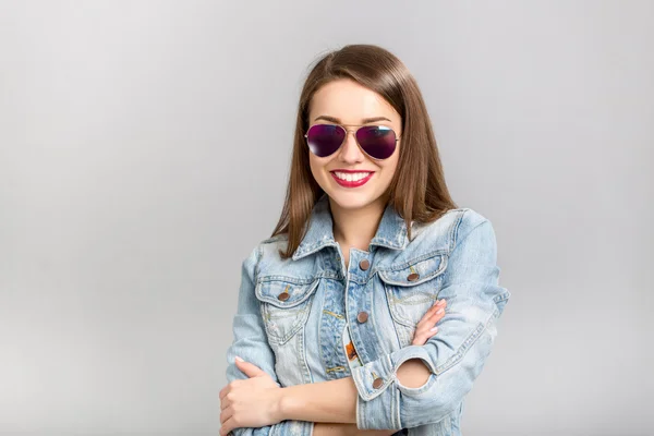 Modelo de moda con pelo liso usando gafas de sol y chaqueta de mezclilla — Foto de Stock