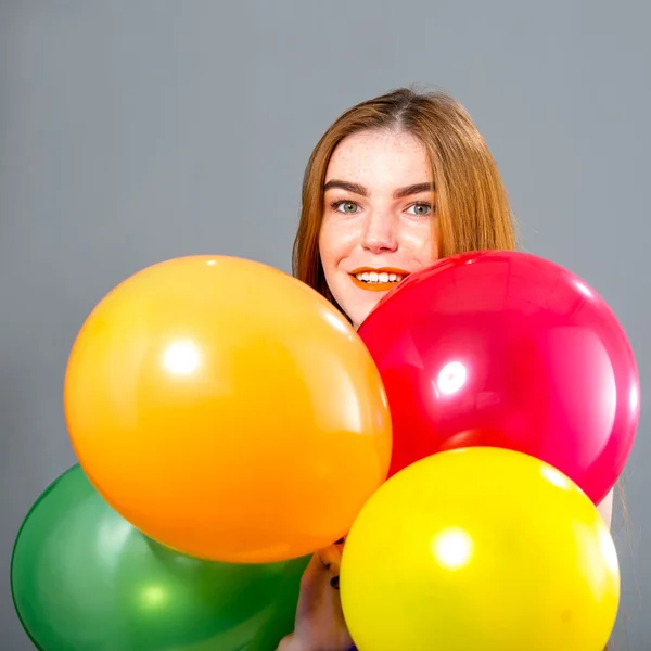 Frau mit roten Haaren und farbigen Luftballons — Stockfoto