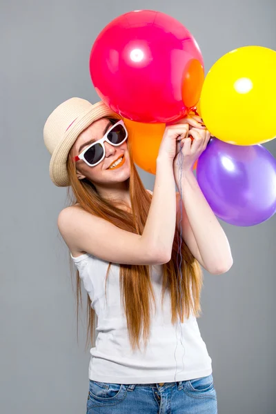 Frau mit roten Haaren und farbigen Luftballons — Stockfoto