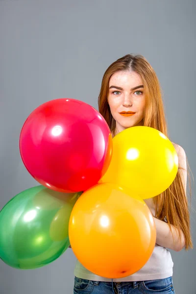 Mulher de cabelo vermelho com balões coloridos — Fotografia de Stock