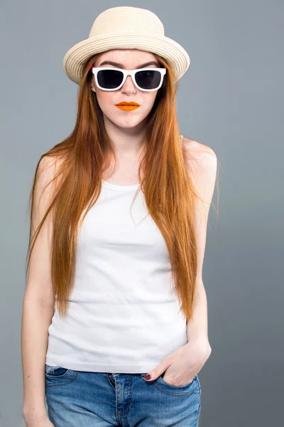 Молодая хипстерша в шляпе и солнцезащитных очках — стоковое фото