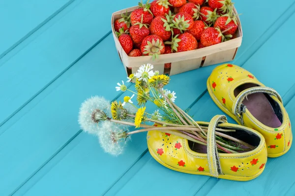 Sommaren bakgrund med jordgubbar, blommor och lite skor — Stockfoto