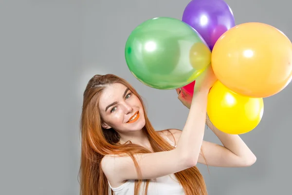 Lustige Frau mit roten Haaren und bunten Luftballons — Stockfoto