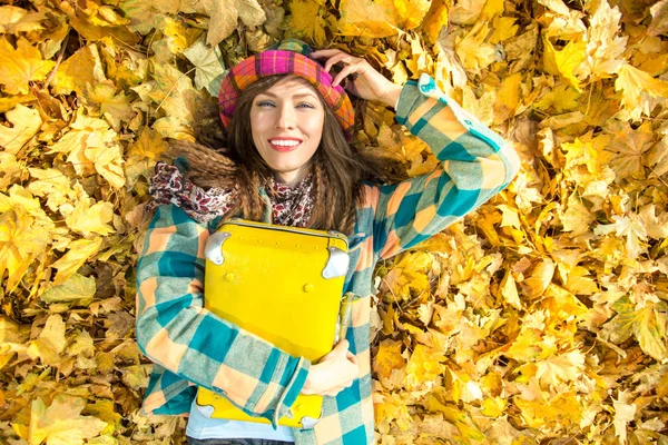 Beautiful woman wearing bright clothes with yellow suitcase — Stock Photo, Image