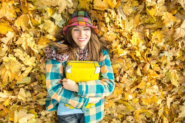 Beautiful woman wearing bright clothes with yellow suitcase — Stock Photo, Image