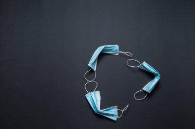 Kullanılmış tıbbi maskeden yapılmış geri dönüşüm işareti. Geri dönüşüm kutusuna tıbbi maske takıyor. Kullandıktan sonra mavi maskeler. Tıbbi maskeler