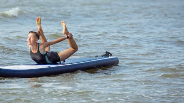 SUP Ayağa kalk, raket tahtası. İki arkadaş kumsalda yemek servisi yapıyor.