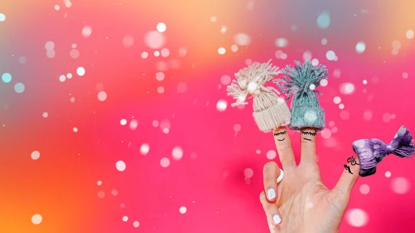 有趣的手指朋友概念毛织帽子粉红背景与降雪 — 图库照片