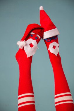 Güzel Noel bacakları. Suratlı çoraplar ve Noel Baba şapkaları giyen komik kadın bacakları. Noel partisi, bayram kutlaması, Noel indirimi.