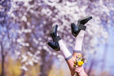 Çiçek açan ağaç arka planında dişi bacaklar