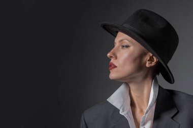 Şapkalı ve erkek arkadaşı olan güzel bir kadının portresi. Kocaman bir takım elbise. Retro kadın