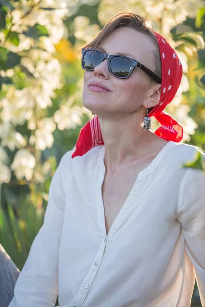 Gün batımında kırsal elbiseli bir kadın, yaz tarlasında gül bahçesinde yürüyor.