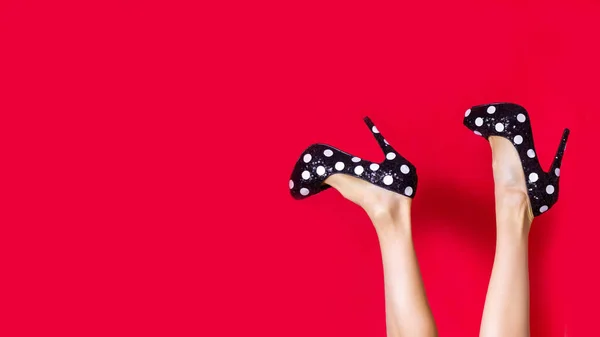 Patas Femeninas Zapatos Negros Con Puntos Blancos Sobre Fondo Rojo — Foto de Stock