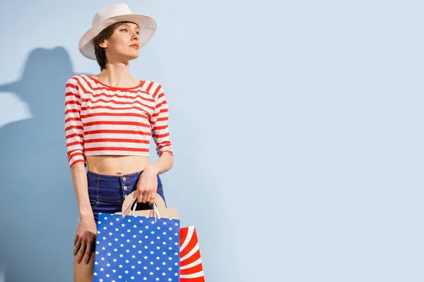 Gelukkig Winkelende Vrouw Met Boodschappentassen Blauwe Achtergrond Met Gestreepte Kleding — Stockfoto