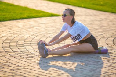 Güzel bir kadın yaz parkında yoga egzersizleri yapıyor. 