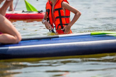 Boy in a life jacket for water sport on . Boy or girl wearing personal flotation device vest for sup study