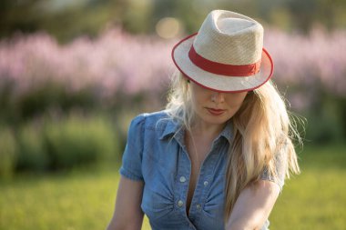 Parktaki yaz şapkalı güzel kadın, şapkaya odaklan.