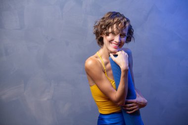 Spor kıyafetli spor kadın gri duvarda spor yapıyor.