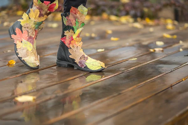 Осінні ноги в кумедних чоботях з опалого листя — стокове фото