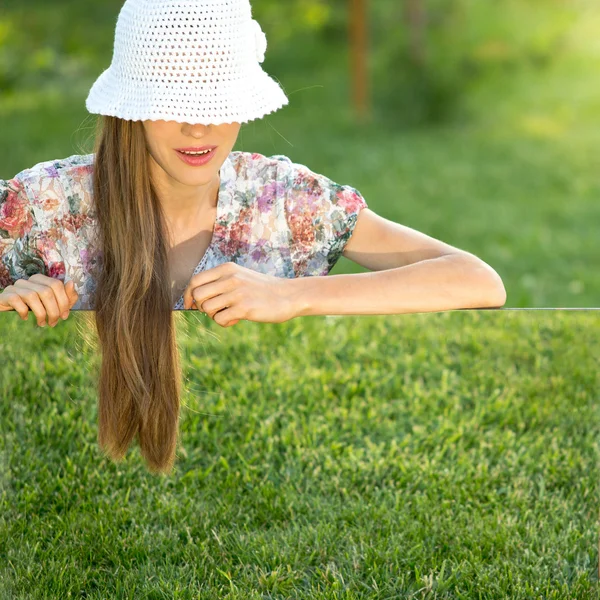 Jeune femme portant un chapeau sur l'herbe verte — Photo